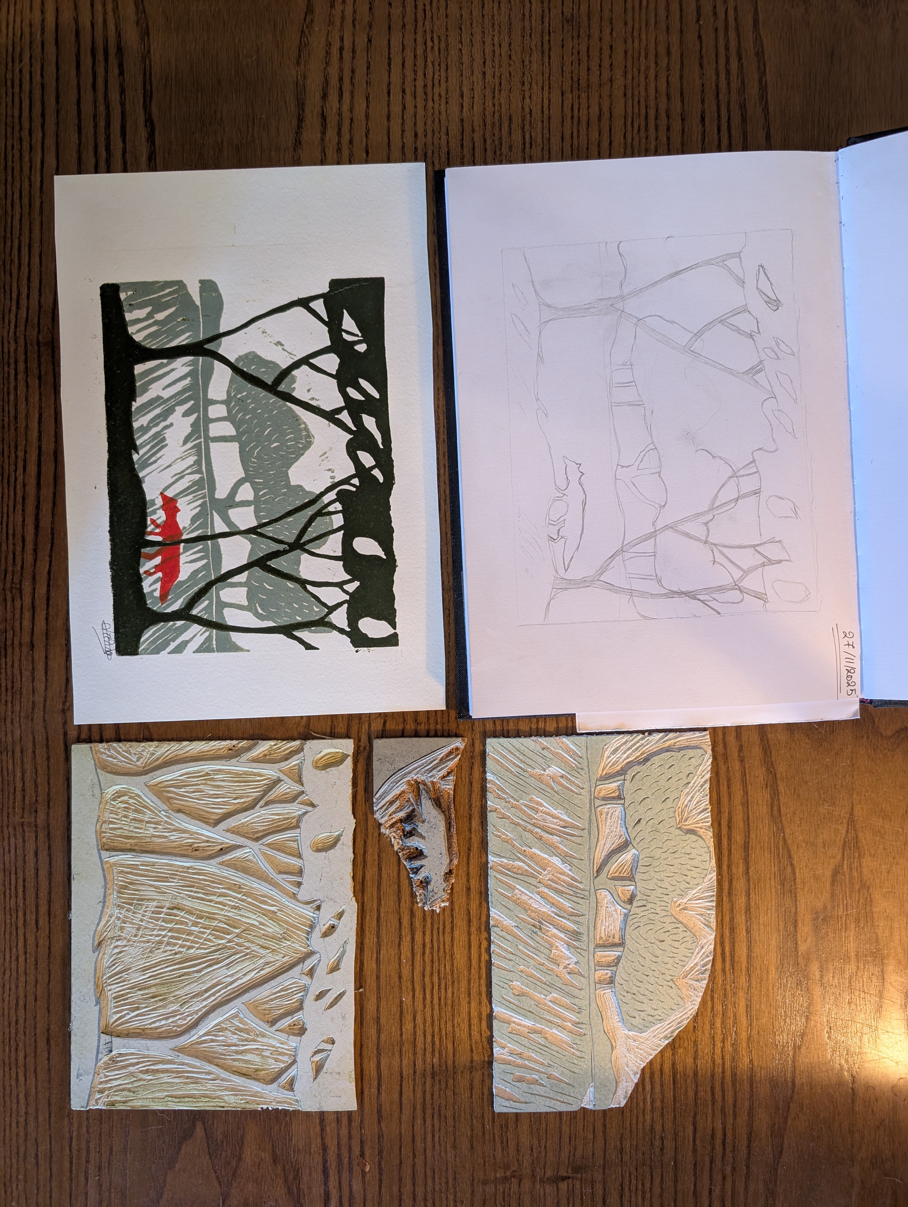 A process photo of the creation of a multiblock linocut print. The composition includes the initial pencil sketch, the completed print of a red fox walking through a stylized woodland landscape and the three carved linoleum blocks used to print the individual color layers. The blocks separate the background landscape, foreground trees and fox, demonstrating the layered printmaking process from concept to finished artwork.